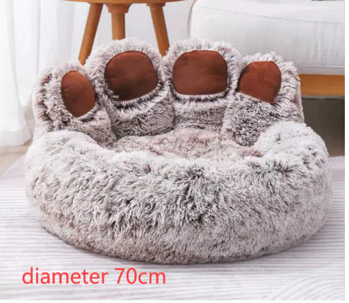 Fluffy pet bed with paw design on a white surface