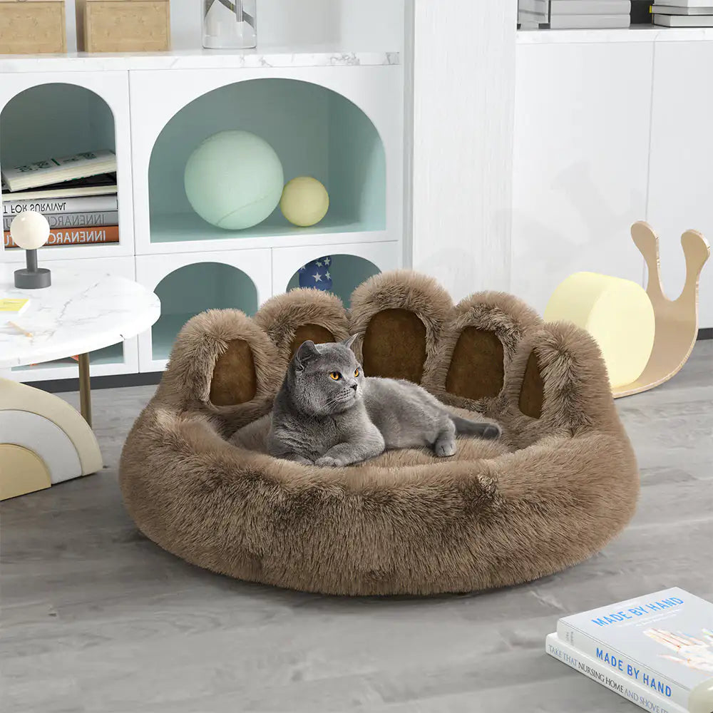 Cat lying on a fluffy paw-shaped pet bed in a modern living room.